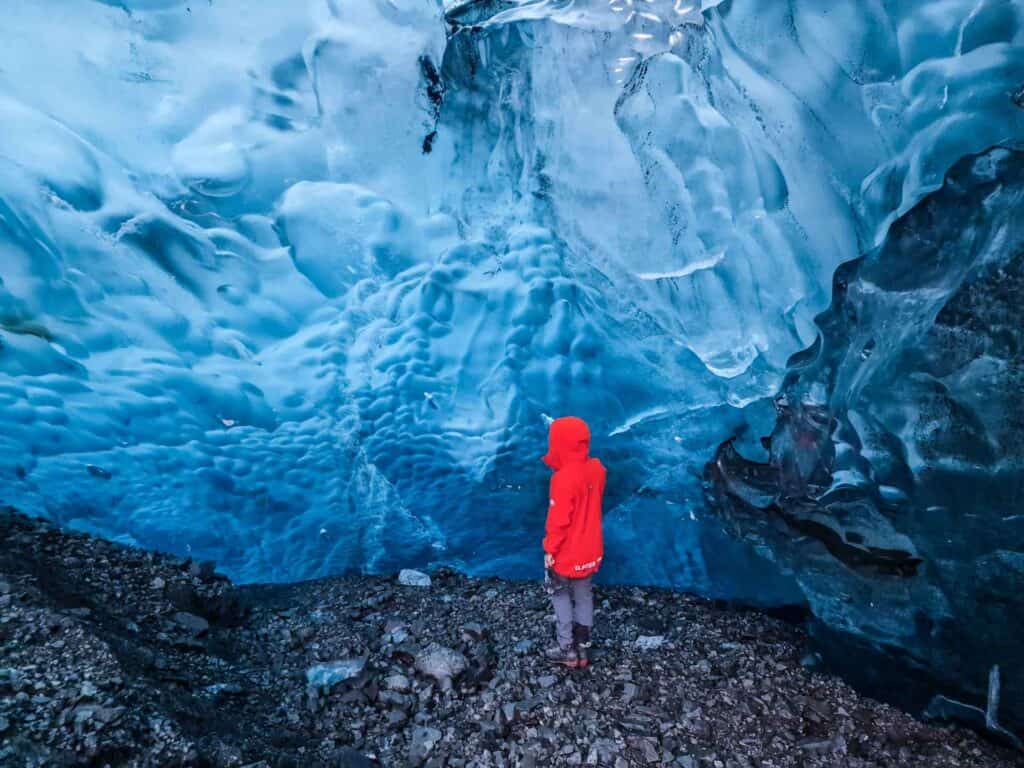 Person in red jacket near blue ice