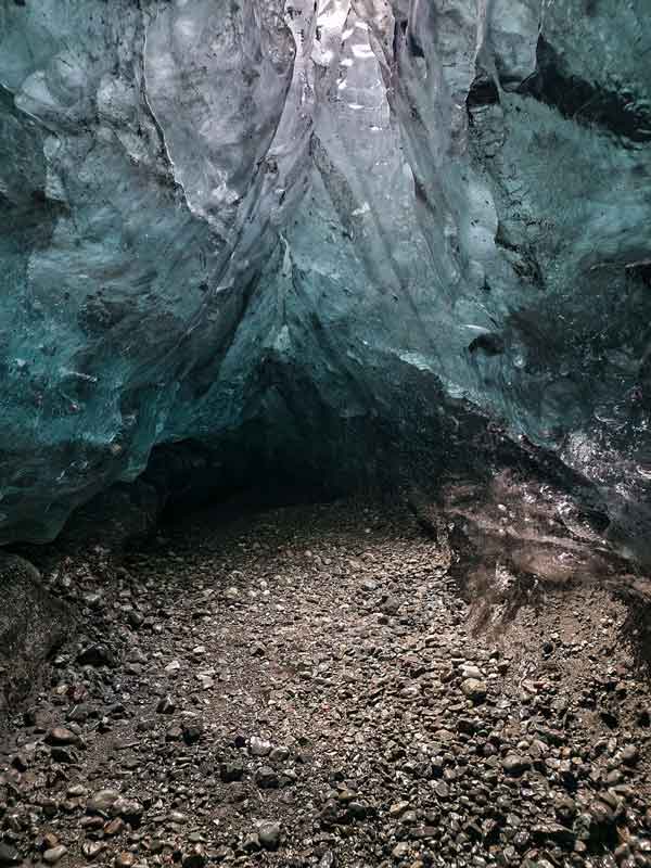Glacial cave with rocky floor.