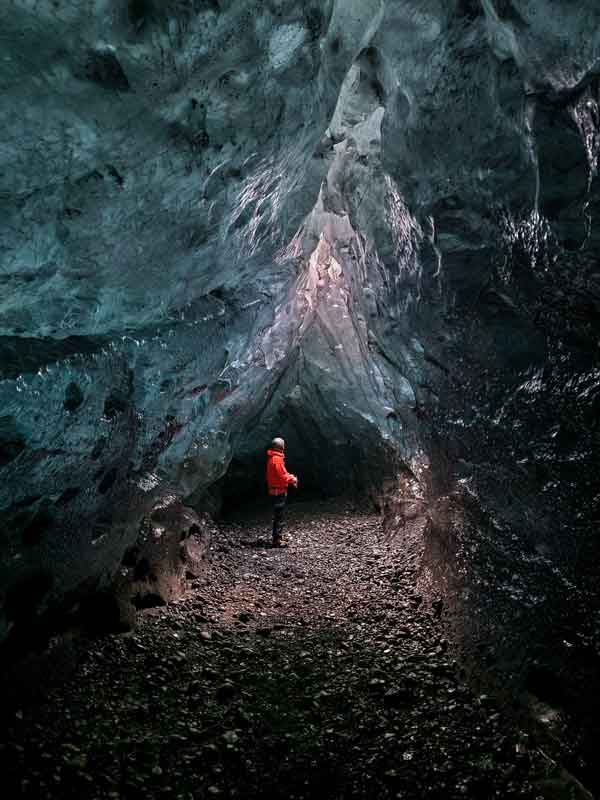 Person standing in blue ice cave in iceland, Atlantis ice cave