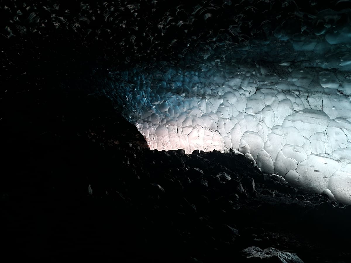 Daylight glowing through the entrance of a natural Vatnajökull ice cave
